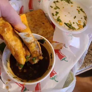 a hand dipping a taqueria into a bowl