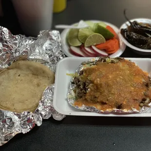 Papanchas: Carne Asada atop Mashed Potatoes, Topped with Cabbage, Cheese, House Salsa Sauce Served with Corn Tortillas, Jalapeños &amp; Veggies