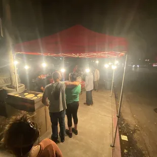 a group of people standing under a tent