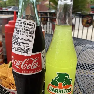 a bottle of coca cola and a bottle of carrots