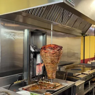 a large kebab being cooked in a commercial kitchen