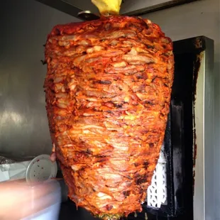 Taquero cutting the sweet tasty pork Al-Pastor meat...