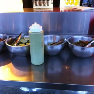 Condiments (cilantro and hot sauces), cucumbers, 2 types of pickled peppers/onions.