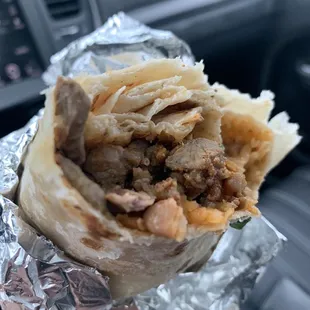 a hand holding a burrito