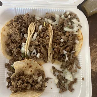 two tacoss in a styrofoam container