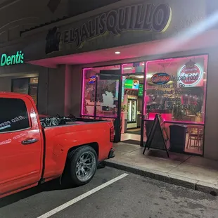 a red truck parked in front of a restaurant