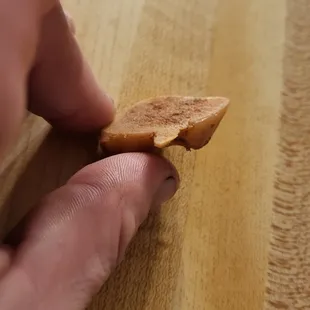 a hand holding a piece of bread