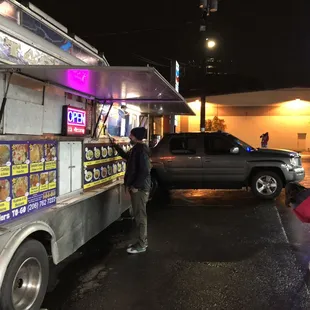 a woman bending over to pick up food from a truck