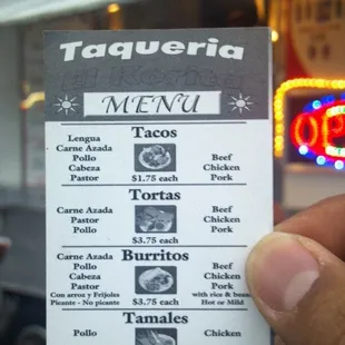 a hand holding a menu