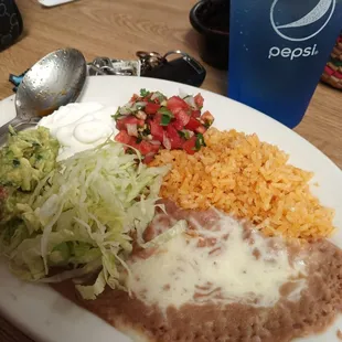 Beans, rice, veggies, sour cream, and guacamole that comes with the fajitas.