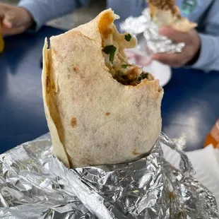 a hand holding a burrito