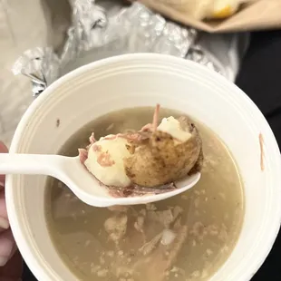 a person holding a spoon full of soup