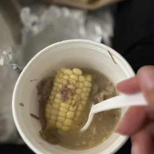 a person eating a corn soup
