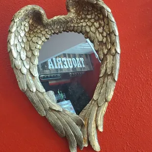a heart shaped mirror on a red wall