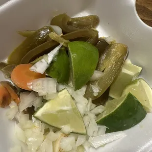 Accoutrements, onion, lime wedges, pickled peppers and carrots