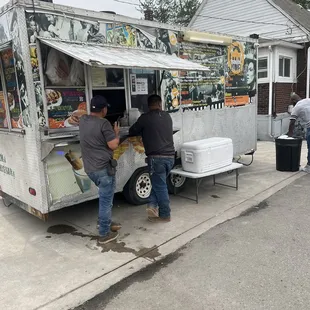 two men loading food from a truck