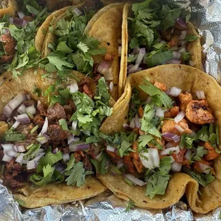 Tacos clockwise from top left: Al pastor, lomo, carnitas, pollo, and campechano.