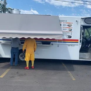 a man and a woman standing in front of a food truck