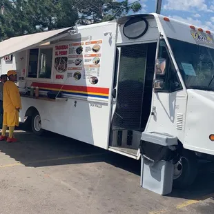 a woman standing in front of a food truck