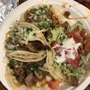 Four tacos, clockwise from the top: al pastor, pescado, lengua, carnitas