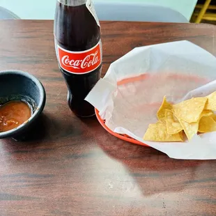 a bottle of coke and a basket of chips