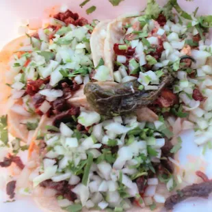 From left, al pastor, carne asada and carnitas tacos, with extra onion and cilantro, all delicious