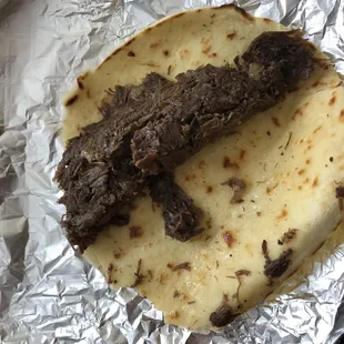 a piece of meat on a tortilla