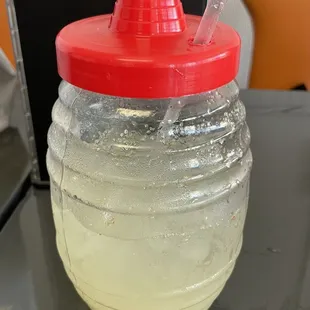 a plastic jug with a straw in it