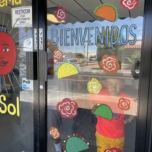 a child in front of a store window