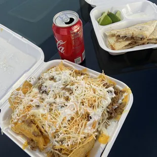 a can of coke and a plate of nachos
