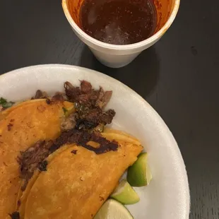 a plate of tacos and a bowl of sauce