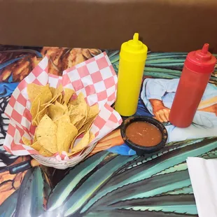 a table with chips and condiments