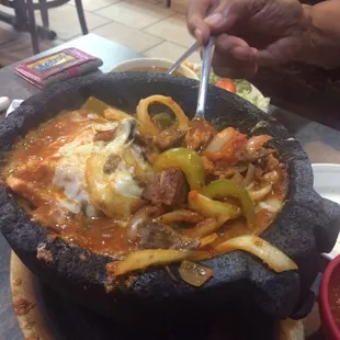 Molcajete steaming hot onions, bell pepper , chicken, beef, sausage, tomatoes.. Feeds 3-4