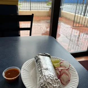 a burrito on a paper plate