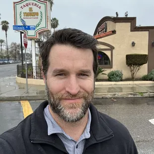 a man standing in front of a restaurant