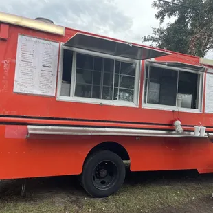 a man and a woman standing in front of a food truck