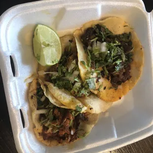 two tacos in a styrofoam container