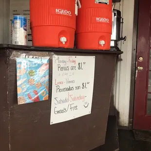 two red coolers on a shelf