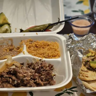 Caritas plate w/ grilled onions, a large jalapeño, tomato slices, avocado slice, rice, and beans. The tortillas are in a separate.