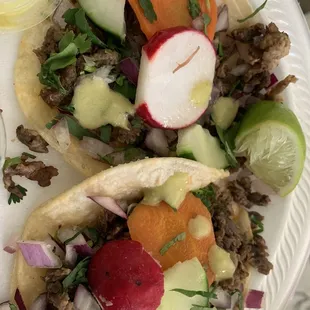 Tacos de carne asada with complimentary veggies and salsa verde