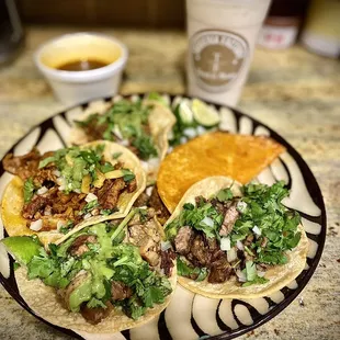 a plate of tacos and a drink