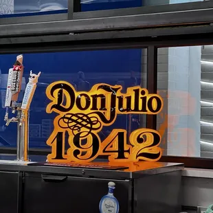 a taqueria counter with a sign that reads,