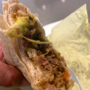 a hand holding a burrito