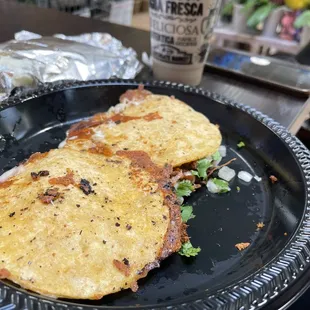 two quesadillas on a black plate