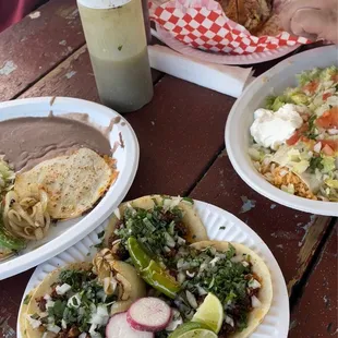 three plates of mexican food on a picnic table