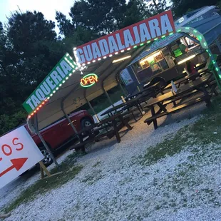 a taco stand with a neon sign