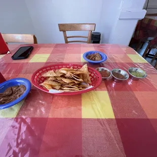 a table with chips and salsa