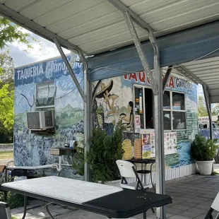 tables and chairs under a awning