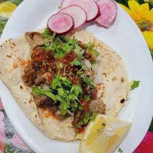 a plate of tacos and a lemon wedge