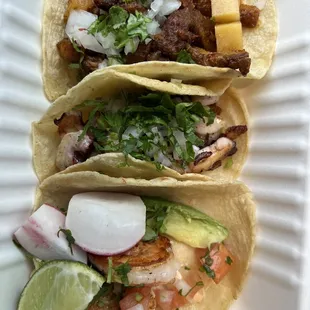 three tacos on a paper plate